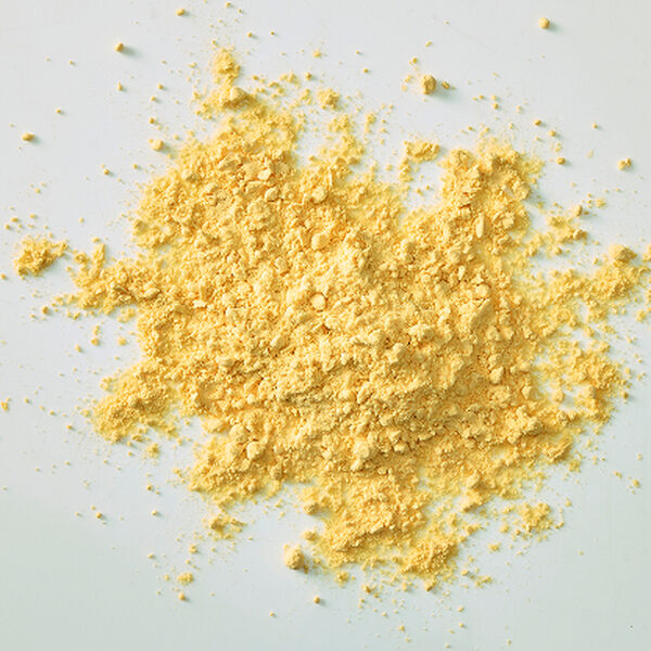 Bright yellow egg powder scattered in a loose pile on a pale surface
