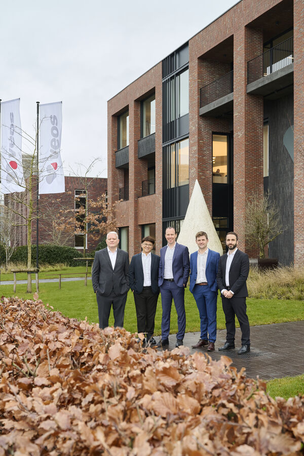 Group photo of veos team on grass outdoors in sunlight